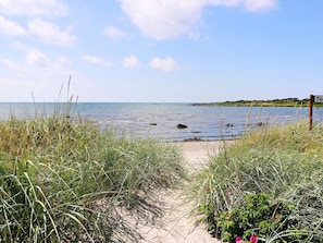 A beach path leading to the sea with a signpost and vegetation. - 3 Person Holiday Home in Traslovslage (Träslövsläge)