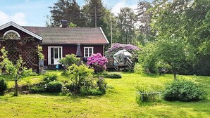 A house with a garden, a wooden structure, and a lawn. - 4 Star Holiday Home in Jorlanda (Jorlanda)