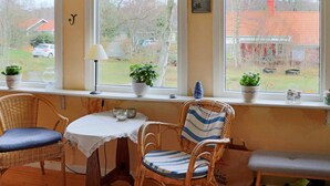 A cozy room with wicker chairs, a small table with a lace tablecloth, and potted plants on a windowsill. - 7 Person Holiday Home in Falkenberg-by Traum (Falkenberg)