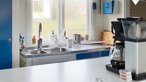 A modern kitchen with a stainless steel sink, a coffee maker, and a window with a view of the outdoors. - 7 Person Holiday Home in Falkenberg-by Traum (Falkenberg)
