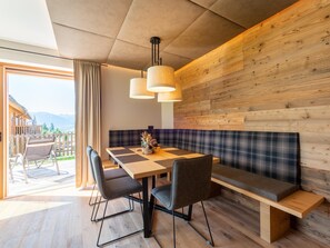 A modern dining area with a wooden table, chairs, and a bench. - Beautiful Chalet With Sauna in Wolting (Tamsweg)