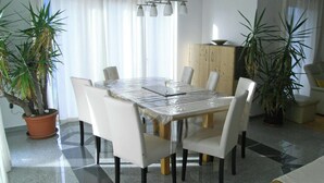 A dining area with a table covered in plastic, surrounded by chairs, and potted plants. - Apartment in Aschau Near Ski Lift Kaltenbach (Aschau Im Zillertal)
