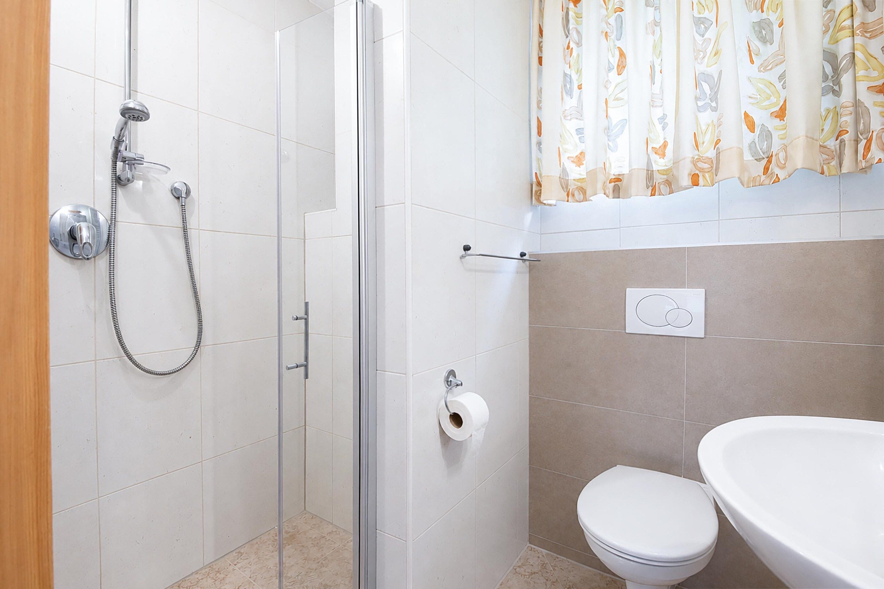Un baño con ducha, inodoro y lavabo.