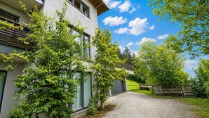 A modern two-story building with a gravel driveway leading to a wooden gate. - Apartment in Aschau Near Ski Lift Kaltenbach (Aschau Im Zillertal)