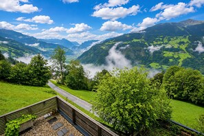 A scenic mountain landscape with a road leading through a valley, surrounded by lush greenery and distant mountains. - Apartment in Aschau Near Ski Lift Kaltenbach (Aschau Im Zillertal)