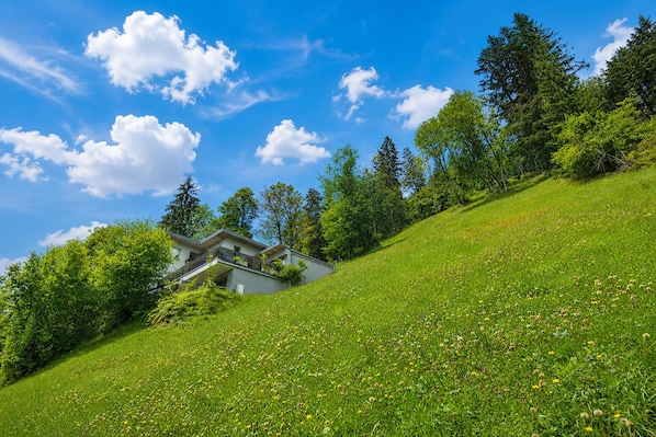 A modern house on a grassy hill with a clear blue sky. - Apartment in Aschau Near Ski Lift Kaltenbach (Aschau Im Zillertal)