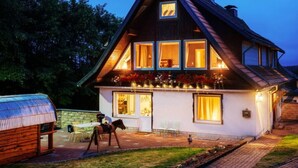 A two-story chalet with a sloped roof, large windows, and a balcony with flower boxes. - Fingerhut Comfortable Holiday Residence (Braunlage)