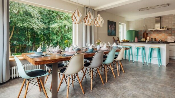 A modern dining area with a wooden table, multiple chairs, and pendant lighting. - Fingerhut Comfortable Holiday Residence (Braunlage)