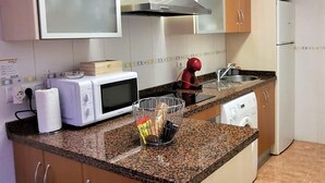 Una cocina equipada con microondas, tostadora, hervidor y lavavajillas.