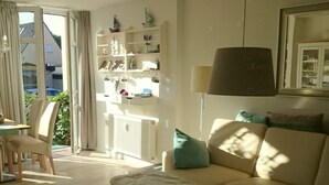 Uma sala de estar com um sofá, uma mesa de centro e uma estante de livros.