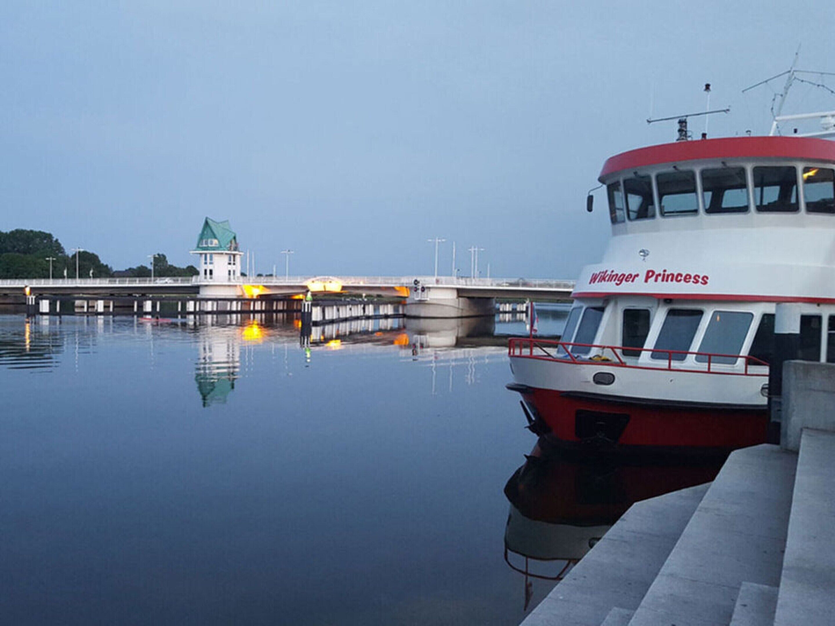 A boat named 'Wiking Princess' docked at a pier with a small building in the background.