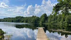 A calm lake with a wooden dock extending into the water, surrounded by dense trees. - 4 Star Holiday Home in Olofstrom (Olofström)