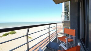Uma varanda com vista para a praia e o oceano.