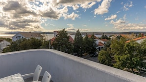 Uma varanda com vista para um lago e casas.