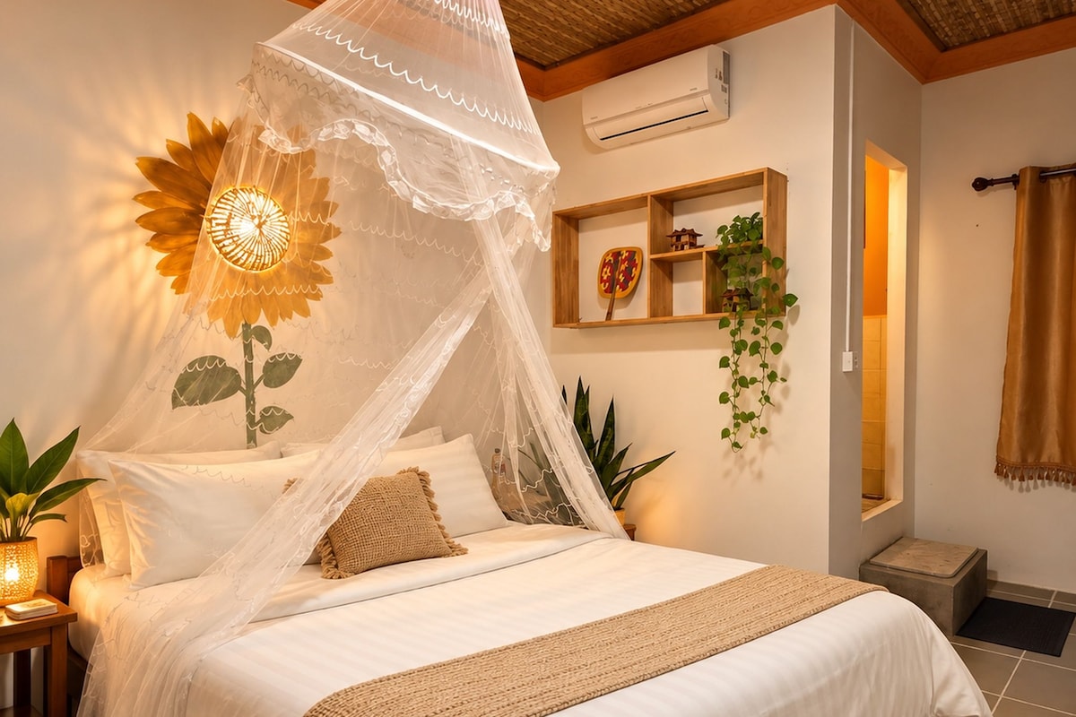 A bedroom with a bed, a bedside table, a wall-mounted air conditioner, a shelf with decorative items, and a potted plant.