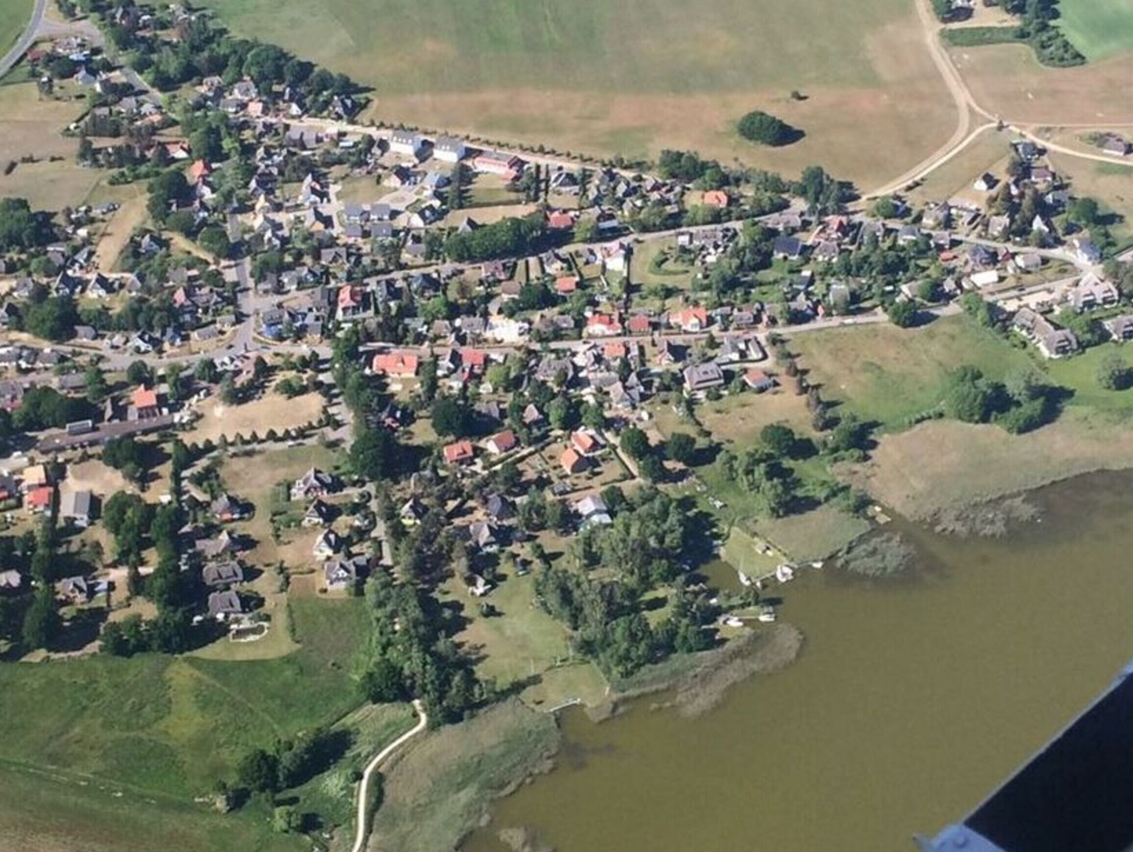Eine Luftaufnahme einer kleinen Stadt mit Häusern, Straßen und einem Fluss.