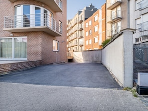 A narrow alleyway between residential buildings with brick facades and balconies. - Nevada Apartment Near the Beach (Koksijde)