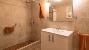 A bathroom with a shower, a sink, and a mirror.