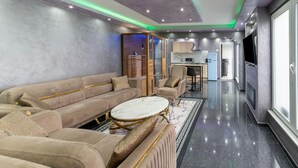A modern living room with a sofa, armchairs, a coffee table, and a TV. - Holiday Home in Verviers With Sauna (Verviers)