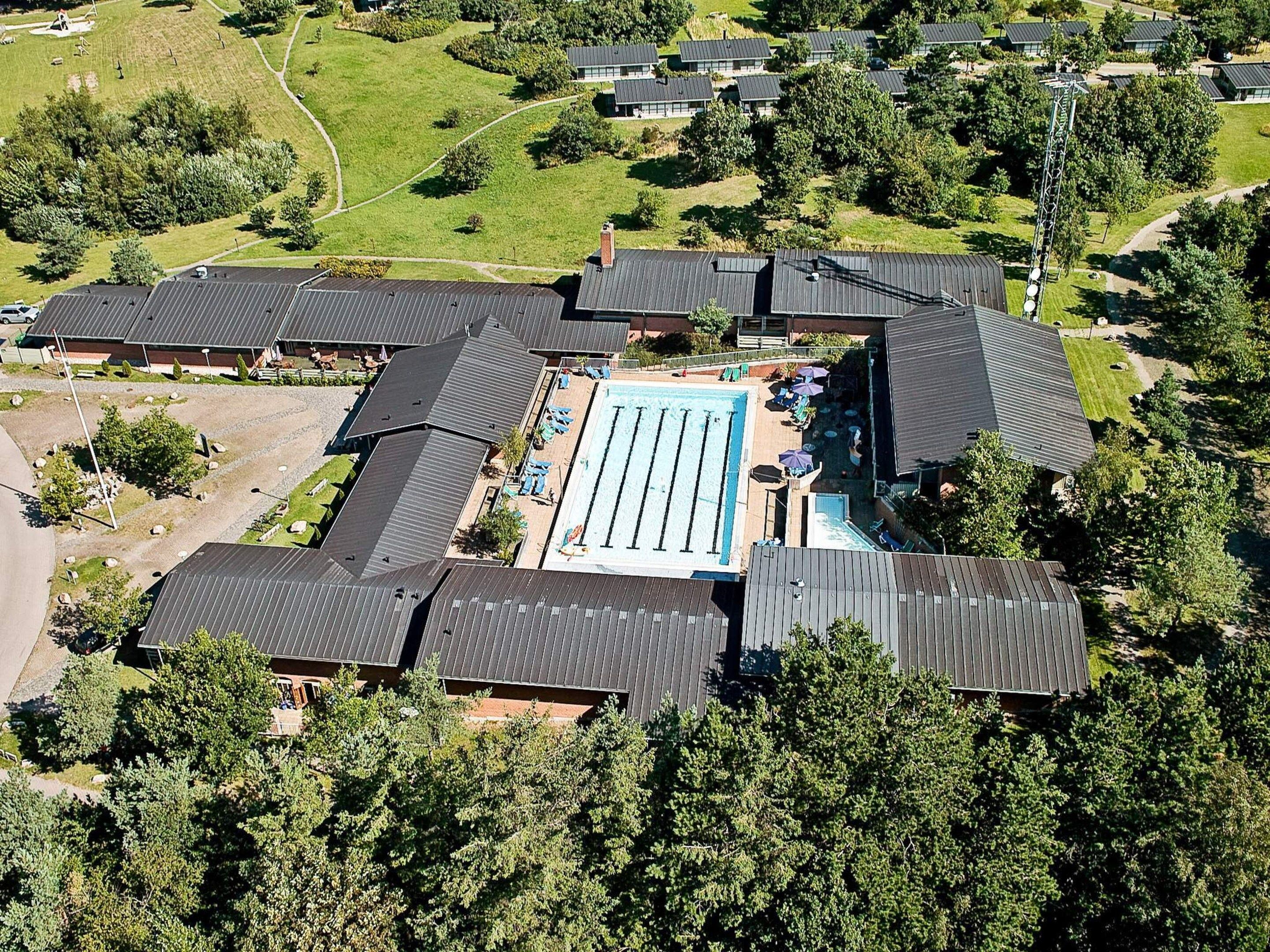 Eine Vogelperspektive auf ein Wohngebiet mit mehreren Häusern, einem Swimmingpool und einem großen Grünland.