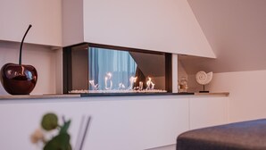 Ein modernes Wohnzimmer mit Kamin, einer dekorativen Apfelsorte und einer kleinen Skulptur.