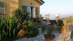 A terrace with outdoor furniture, potted plants, and a stone pathway. - Holiday Apartment Monte Faudo (Cipressa)