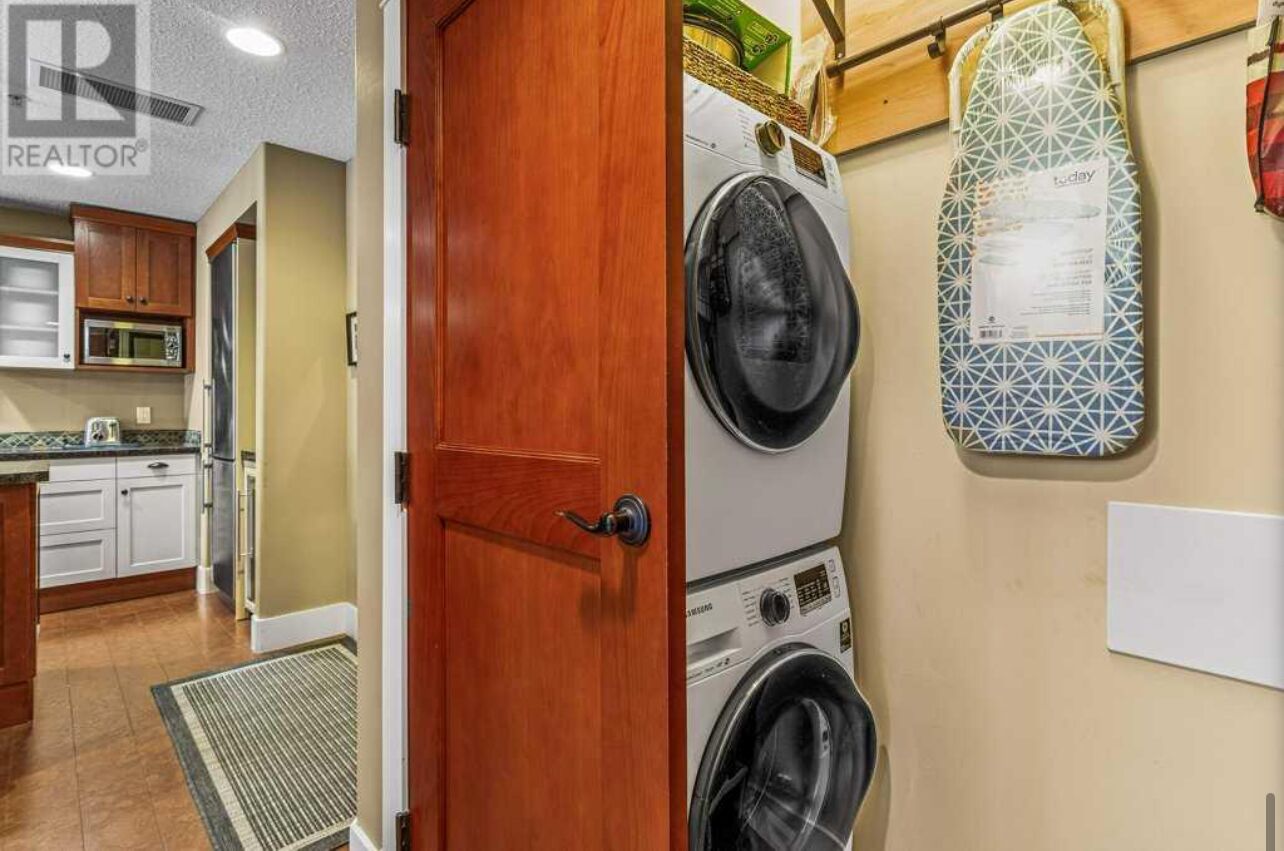 A laundry room with a washing machine, dryer, and ironing board.