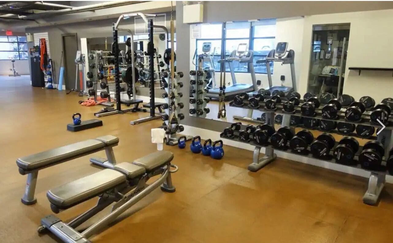 Una palestra con attrezzi per sollevamento pesi, tapis roulant e macchinari per esercizi.