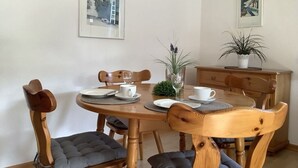 A dining area with a wooden table, chairs, and a vase of flowers. - Appartementencomplex Titisee (Titisee-Neustadt)