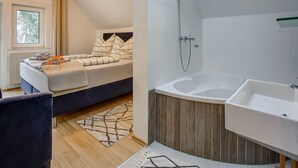 Ein modernes Schlafzimmer mit Bett, Dusche und Bad.