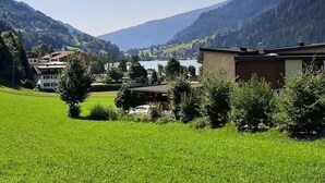 Ländliche Landschaft mit einem See, Bergen und einem Gebäude mit flachem Dach.