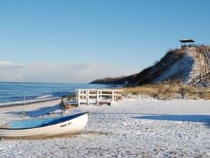 A beach with a boat named 'ER 47' and a small white structure with a roof. - Charming Apartment in Ostseebad Rerik (Rerik)