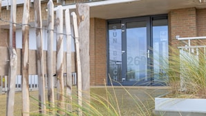 Een gebouwtoegang met een glazen deur waarop 'SUNDAY 26' staat.