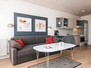 A modern living room with a grey sofa, a white coffee table, and abstract art on the wall. - 6 Person Holiday Park Home in Hejls (Hejls)