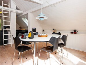 A dining area with a round table, black chairs, and a blue pendant light. - 6 Person Holiday Home in Hemmet-by Traum (Hemmet)