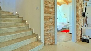 A staircase leading to a bedroom with a stone wall and a red rug. - Patricia Comfortable Holiday Residence (Kanfanar)