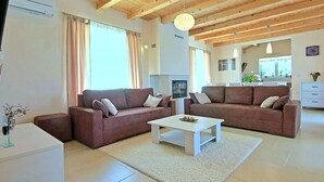 A modern living room with two sofas, a coffee table, and a fireplace. - Patricia Comfortable Holiday Residence (Kanfanar)
