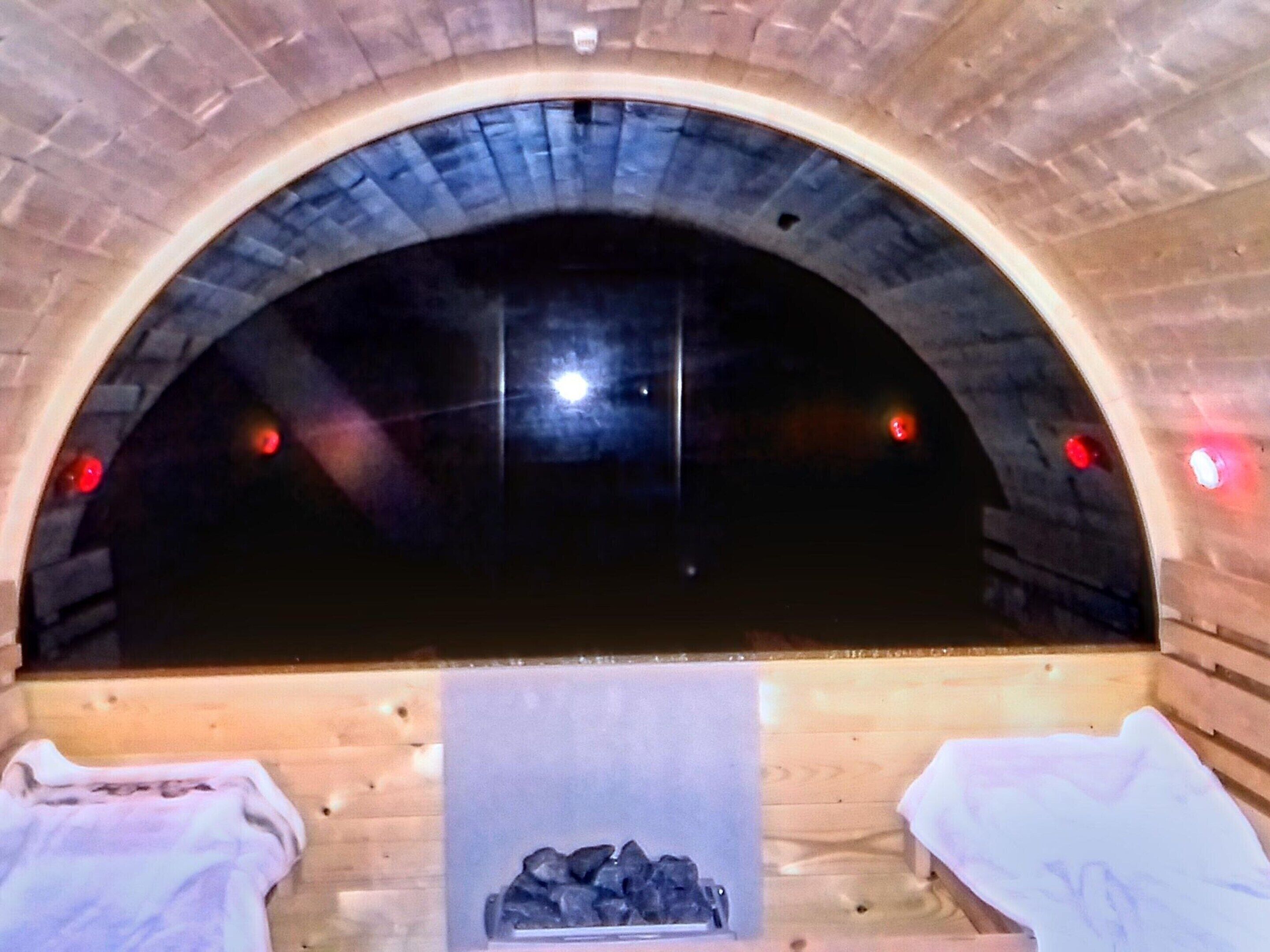 Un sauna doté d’une arche en briques, d’un banc et d’un tas de pierres.