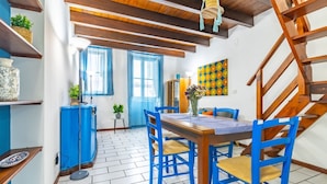 A dining area with a wooden table, blue chairs, and a blue cabinet.