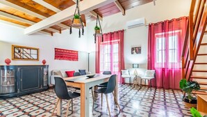 Un comedor con una mesa y sillas de madera, un armario negro y un suelo estampado.