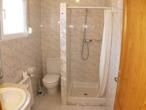 Ein Badezimmer mit Toilette, Waschbecken und Dusche.