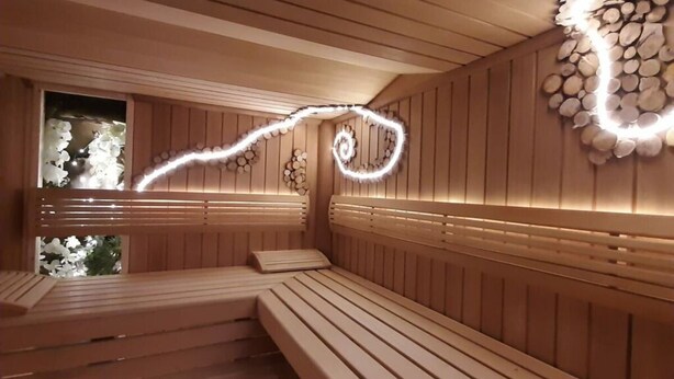 A sauna with wooden benches and a decorative wall. - Under the District Administrator's Mountain (Treffurt)