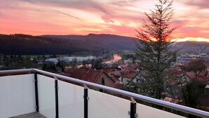 A balcony with a metal railing overlooking a town during sunset. - Under the District Administrator's Mountain (Treffurt)