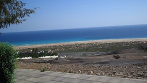 A coastal landscape with a beach, a clear sky, and a distant view of the ocean. - Belvilla by OYO Holiday Home in Jandaa (Pajara)