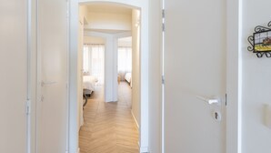 A hallway leading to a bedroom with a wooden floor and white walls. - Bright Apartment With Direct sea View (Middelkerke)
