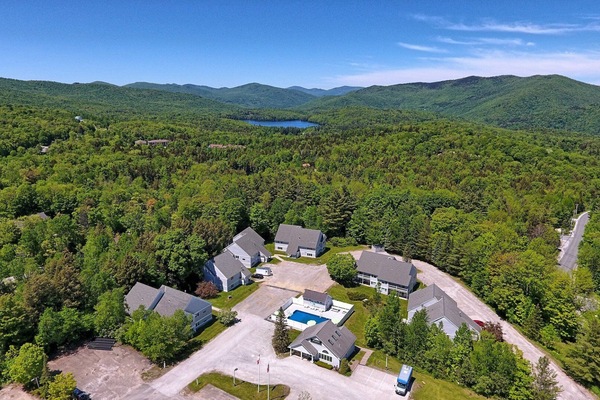 From above, the outdoor pool sits among the condo buildings with wooded hills stretching beyond.