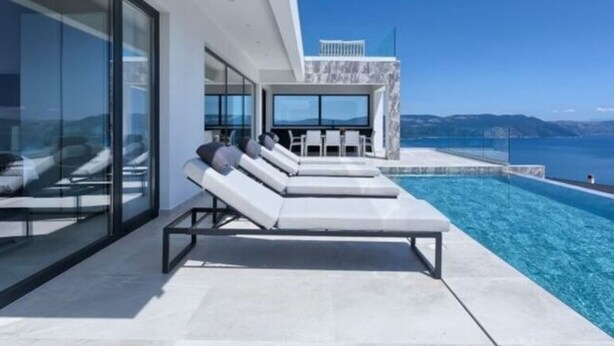 A modern poolside area with lounge chairs and a clear view of the sea. - Villa Ateneum Comfortable Holiday Residence (Labin)