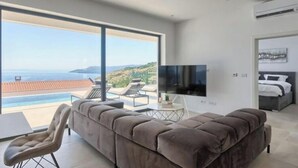 A modern bedroom with a large window, a flat-screen TV, and a bed. - Villa Ateneum Comfortable Holiday Residence (Labin)