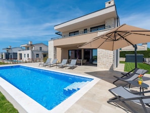 A modern two-story house with a swimming pool, outdoor seating, and a covered patio area. - Villa Mahalo Modern Retreat (Sveti Lovrec)
