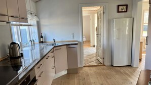 Een moderne keuken met een inbouwoven, een gootsteen en een koelkast.